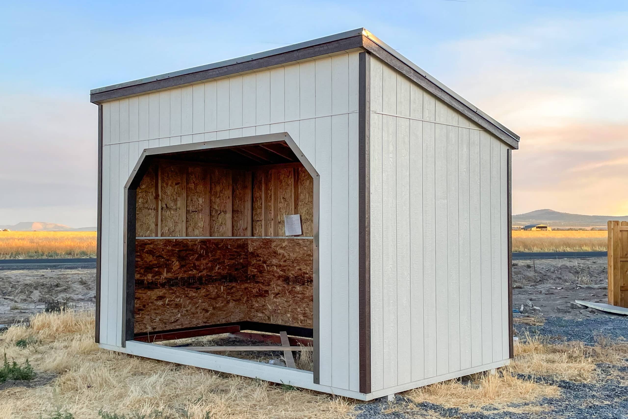 white dog house with brown trim and mono sloped roof